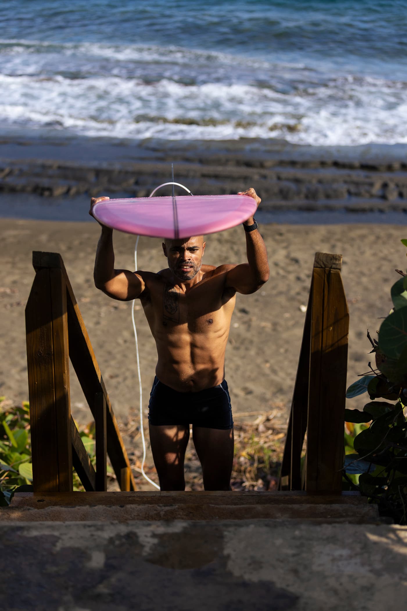 Surfboard on stairs leading to the beach