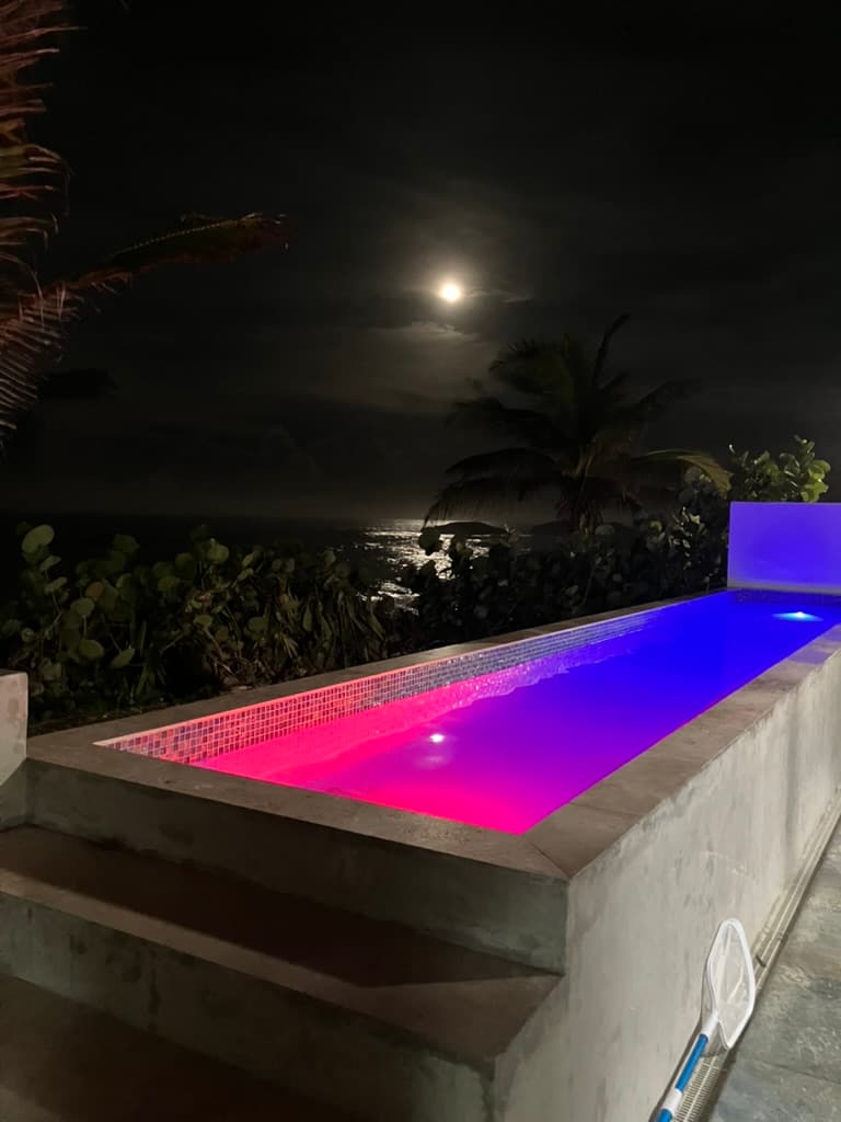 Full moon reflected on the Atlantic beyond the illuminated infinity pool