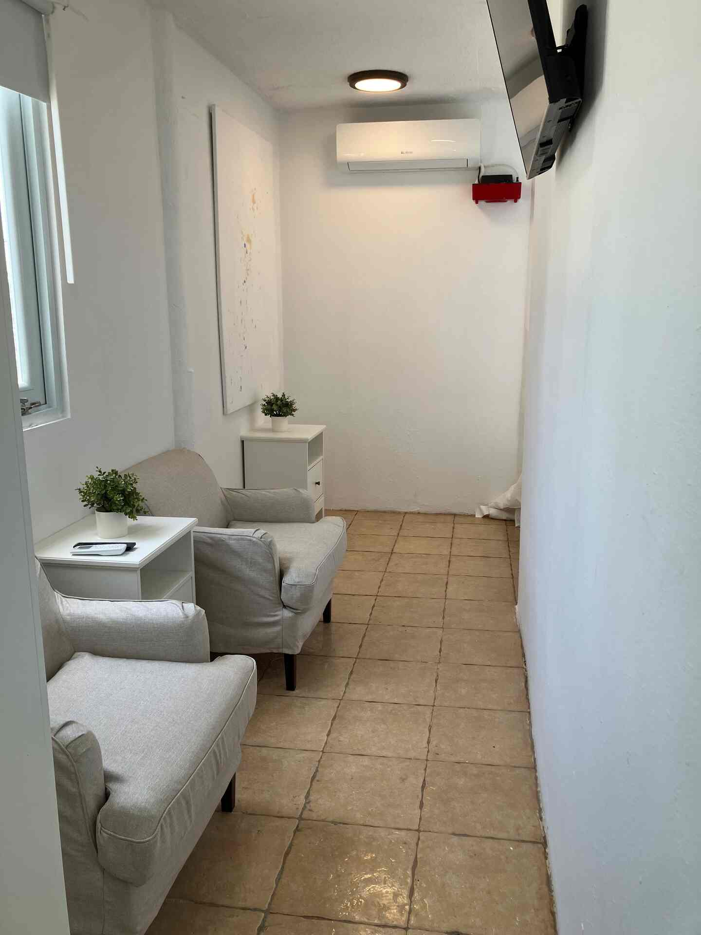 Private game lounge with two chairs and wall-mounted TV beside Bedroom 4